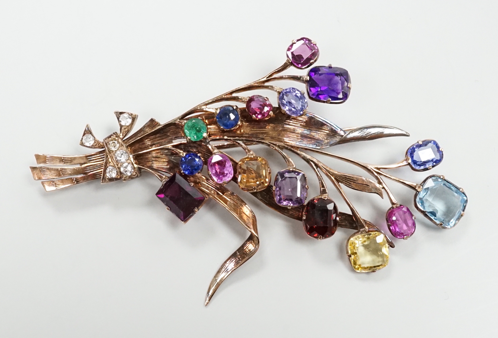 A yellow metal and multi gem set floral spray brooch, 77mm, gross weight 12.5 grams.